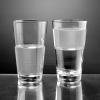 Product shot of water glass half full and half empty