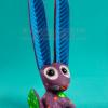 Colorful wooden jackrabbit sculpture on turquoise background